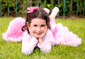 girl with pink bow in the grass